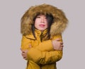 Young beautiful Asian Chinese woman feeling cold and chilly freezing feeling cold in Winter weather wearing yellow jacket with fur Royalty Free Stock Photo