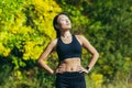 Young beautiful asian female athlete in black sports suit leggings and t-shirt, resting after workout, with closed eyes Royalty Free Stock Photo