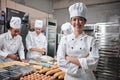 Young beautiful Asian female chef looks at camera, a cheerful smile in kitchen Royalty Free Stock Photo