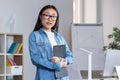 Young beautiful Asian female teacher looking at the camera and smiling, portrait of a woman in the office Royalty Free Stock Photo