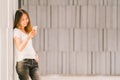 Young beautiful Asian girl or college student using smartphone and smiling. Modern lifestyle, communication technology concept Royalty Free Stock Photo