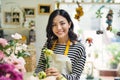 Young beautiful asian girl florist taking care of flowers at wor