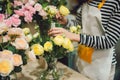 Young beautiful asian girl florist taking care of flowers at workplace