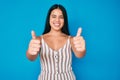 Young beautiful asian girl wearing casual clothes approving doing positive gesture with hand, thumbs up smiling and happy for Royalty Free Stock Photo