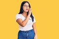 Young beautiful asian girl wearing casual clothes and glasses hand on mouth telling secret rumor, whispering malicious talk Royalty Free Stock Photo