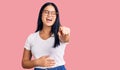 Young beautiful asian girl wearing casual clothes and glasses laughing at you, pointing finger to the camera with hand over body, Royalty Free Stock Photo