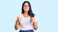 Young beautiful asian girl wearing casual clothes and glasses success sign doing positive gesture with hand, thumbs up smiling and Royalty Free Stock Photo