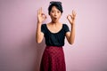 Young beautiful asian girl wearing casual dress standing over isolated pink background looking surprised and shocked doing ok Royalty Free Stock Photo