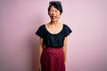 Young beautiful asian girl wearing casual dress standing over isolated pink background sticking tongue out happy with funny Royalty Free Stock Photo