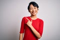 Young beautiful asian girl wearing casual red t-shirt standing over isolated white background cheerful with a smile on face Royalty Free Stock Photo