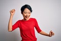 Young beautiful asian girl wearing casual red t-shirt standing over isolated white background Dancing happy and cheerful, smiling Royalty Free Stock Photo