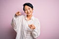 Young beautiful asian girl wearing casual shirt standing over isolated pink background pointing to you and the camera with Royalty Free Stock Photo