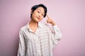 Young beautiful asian girl wearing casual shirt standing over isolated pink background Smiling pointing to head with one finger, Royalty Free Stock Photo
