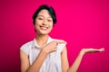 Young beautiful asian girl wearing casual summer shirt standing over isolated pink background amazed and smiling to the camera Royalty Free Stock Photo