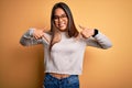 Young beautiful asian girl wearing casual sweater and glasses over yellow background looking confident with smile on face, Royalty Free Stock Photo