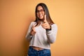 Young beautiful asian girl wearing casual sweater and glasses over yellow background pointing fingers to camera with happy and Royalty Free Stock Photo