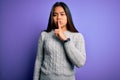 Young beautiful asian girl wearing casual sweater standing over isolated purple background asking to be quiet with finger on lips Royalty Free Stock Photo