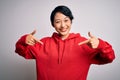 Young beautiful asian girl wearing casual sweatshirt with hoodie over white background looking confident with smile on face, Royalty Free Stock Photo