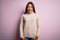 Young beautiful asian girl wearing casual turtleneck sweater over isolated pink background sticking tongue out happy with funny Royalty Free Stock Photo