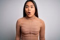 Young beautiful asian girl wearing casual turtleneck sweater standing over white background afraid and shocked with surprise Royalty Free Stock Photo