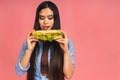 Young beautiful asian japanese chinese woman eating sandwich or big burger with satisfaction. Girl enjoys tasty hamburger takeaway