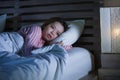 Young beautiful Asian Korean girl lying on bed late night awake looking thoughtful suffering insomnia sleeping disorder feeling Royalty Free Stock Photo
