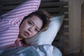 Young beautiful Asian Korean girl lying on bed late night awake looking thoughtful suffering insomnia sleeping disorder feeling Royalty Free Stock Photo