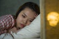 Young beautiful Asian Korean girl lying on bed late night awake looking thoughtful suffering insomnia sleeping disorder feeling Royalty Free Stock Photo