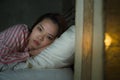 Young beautiful Asian Korean girl lying on bed late night awake looking thoughtful suffering insomnia sleeping disorder feeling Royalty Free Stock Photo