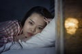 Young beautiful Asian Korean girl lying on bed late night awake looking thoughtful suffering insomnia sleeping disorder feeling Royalty Free Stock Photo