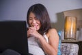 Young beautiful Asian Korean student girl happy and relaxed at home sofa couch using internet on laptop computer networking cheerf Royalty Free Stock Photo