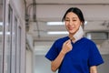 Young beautiful Asian medical nurse in scrub uniform at hospital prepared to wear a face mask. Professional medic at