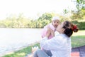 Young beautiful Asian mother kissing her little baby 4 months girl. Family; mother and daughter having a free time relaxing in Royalty Free Stock Photo