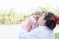 Young beautiful Asian mother kissing her little baby 4 months girl. Family; mother and daughter having a free time relaxing in Royalty Free Stock Photo