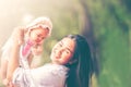 Young beautiful asian mother smiling and holding little baby girl playing in the park Royalty Free Stock Photo