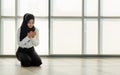 Young and beautiful Asian Muslim woman in black veil sitting on floor and praying with respect and calm manner Royalty Free Stock Photo