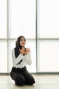 Young and beautiful Asian Muslim woman in black veil sitting on floor and praying with respect and calm manner Royalty Free Stock Photo