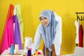 A young beautiful Asian Muslim woman designer who wore a hijab as a startup business owner standing in her working studio room. Royalty Free Stock Photo