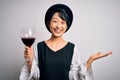 Young beautiful asian sommelier girl drinking glass of red wine over isolated white background very happy and excited, winner