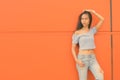 Young beautiful Asian teenage girl against orange wall Royalty Free Stock Photo