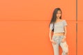 Young beautiful Asian teenage girl against orange wall Royalty Free Stock Photo