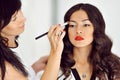 Young beautiful asian woman applying make-up by make-up artist Royalty Free Stock Photo