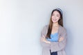 Young beautiful Asian woman in a blue shirt is standing with her arms crossed on a white background Royalty Free Stock Photo