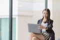 Young beautiful asian woman in casual clothes sits in chair using laptop computer Royalty Free Stock Photo