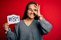 Young beautiful asian woman celebrating 8th march womens day holding reminder paper with happy face smiling doing ok sign with