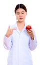 Young beautiful Asian woman doctor holding and pointing at red a Royalty Free Stock Photo