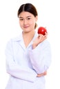 Young beautiful Asian woman doctor holding red apple Royalty Free Stock Photo