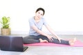 Young beautiful asian woman doing training fitness workout sport exercise feel no stress free, using laptop while sitting on floor Royalty Free Stock Photo