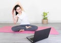 Young beautiful asian woman doing training fitness workout sport exercise feel no stress free, using laptop while sitting on floor Royalty Free Stock Photo