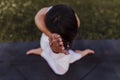 young beautiful asian woman doing yoga in a park at sunset. Yoga and healthy lifestyle concept. Top view. Selective focus Royalty Free Stock Photo